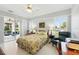 Bright bedroom with a floral bedspread, sliding glass doors, and shuttered windows overlooking the outdoor living space at 3421 Capland Ave, Clermont, FL 34711
