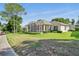 Well-maintained home exterior featuring a screened lanai, lush landscaping, and proximity to the golf course at 3421 Capland Ave, Clermont, FL 34711