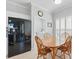 Bright kitchen with wooden table, black refrigerator, white cabinets and natural light from shuttered window at 3421 Capland Ave, Clermont, FL 34711