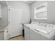 Bright laundry room featuring a full-size washer and dryer, complemented by a granite countertop and tiled flooring at 3421 Capland Ave, Clermont, FL 34711