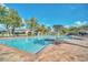 Inviting community pool with clear blue water, brick patio, lounge chairs, and palm trees at 3421 Capland Ave, Clermont, FL 34711