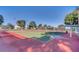 Well-maintained tennis court featuring a green and red surface, nets, and surrounding fencing at 3421 Capland Ave, Clermont, FL 34711
