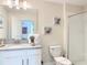 Clean bathroom featuring a single vanity, shower with glass door, and decorative shell art at 345 Ocean Course Ave, Davenport, FL 33896