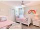 Bright bedroom featuring twin beds with cartoon-themed bedding and a ceiling fan at 345 Ocean Course Ave, Davenport, FL 33896