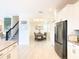 View of the dining area with chandelier and gray tile flooring, as seen from the kitchen at 345 Ocean Course Ave, Davenport, FL 33896