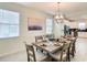 A dining room featuring modern chandelier, a large table set for dining, and multiple windows at 345 Ocean Course Ave, Davenport, FL 33896
