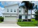 Contemporary two-story home featuring stone accents, a two-car garage, and a well-manicured lawn at 345 Ocean Course Ave, Davenport, FL 33896