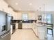 Bright, modern kitchen featuring white cabinets, stainless steel appliances, and an island with seating at 345 Ocean Course Ave, Davenport, FL 33896