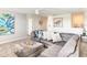 Comfortable living room featuring a large gray sectional sofa, patterned pillows, and modern decor at 345 Ocean Course Ave, Davenport, FL 33896