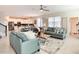 Open-concept living room with sofas, a ceiling fan, and a view into the kitchen at 345 Ocean Course Ave, Davenport, FL 33896