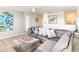 Comfortable living room featuring a large gray sectional sofa, patterned pillows, and modern decor at 345 Ocean Course Ave, Davenport, FL 33896
