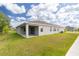 Spacious backyard with a covered patio, lush green lawn, and modern exterior at 348 Conway Ave, St Cloud, FL 34771
