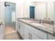 Bright bathroom featuring a double granite vanity, sleek white cabinets, and neutral colored flooring at 348 Conway Ave, St Cloud, FL 34771
