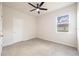 A well-lit bedroom with neutral walls, carpet flooring, a ceiling fan, and a window that offers a pleasant view at 348 Conway Ave, St Cloud, FL 34771