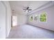 Bright carpeted main bedroom featuring a ceiling fan and three windows at 348 Conway Ave, St Cloud, FL 34771