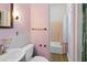 Cozy pink bathroom featuring a sink, toilet, and shower/tub combination at 3503 S Crystal Lake Dr, Orlando, FL 32806