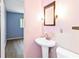 Cozy pink bathroom featuring a sink, toilet, and a glimpse into the blue bedroom at 3503 S Crystal Lake Dr, Orlando, FL 32806