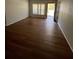 Sunlit living room with new hardwood flooring, neutral walls, and a view of the outdoors through a large window at 3503 S Crystal Lake Dr, Orlando, FL 32806