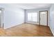 Bright living room featuring hardwood floors, a large window, and a freshly painted white front door at 3503 S Crystal Lake Dr, Orlando, FL 32806