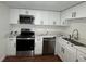 Well-lit kitchen with stainless steel appliances, quartz countertops, white cabinets and sleek hardware at 3815 Nw Avenue R Ave, Winter Haven, FL 33881