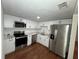 Modern kitchen with stainless steel appliances, white cabinets, quartz countertops, and wood grain floors at 3815 Nw Avenue R Ave, Winter Haven, FL 33881