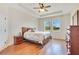 Bright bedroom featuring a tray ceiling, hardwood floors, and view of green space at 3894 Wind Dancer Cir, St Cloud, FL 34772