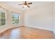 Bright bedroom with hardwood floors, two windows, and a ceiling fan at 3894 Wind Dancer Cir, St Cloud, FL 34772