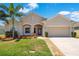 Charming single-story home featuring a well-manicured lawn, palm tree, and neutral-toned facade at 3894 Wind Dancer Cir, St Cloud, FL 34772
