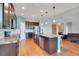 An open concept kitchen featuring granite counters, stainless appliances, an island with seating, and hardwood floors at 3894 Wind Dancer Cir, St Cloud, FL 34772