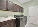 Functional laundry room with modern washer/dryer, sink, and ample cabinet storage at 3894 Wind Dancer Cir, St Cloud, FL 34772