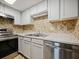 Updated kitchen features stainless steel appliances, white cabinets, and a decorative backsplash for a modern, clean look at 4215 S Semoran Blvd # 15, Orlando, FL 32822