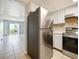 Open kitchen with stainless steel appliances, white cabinetry, and a view into the bright living space with large sliding doors at 4215 S Semoran Blvd # 15, Orlando, FL 32822