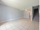 Spacious living area with tile flooring and staircase, offering a blank canvas for personalization and comfortable living at 4215 S Semoran Blvd # 15, Orlando, FL 32822