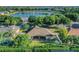 Aerial view of a house with a lake view and a spacious backyard featuring a screened lanai at 506 Alleria Ct, Auburndale, FL 33823