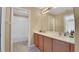 Bright bathroom features double sinks with wood cabinets and a bathtub with tiled walls at 506 Alleria Ct, Auburndale, FL 33823