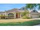 Attractive home with a manicured lawn, mature landscaping, and an inviting front porch with columns at 506 Alleria Ct, Auburndale, FL 33823