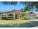 Beautiful home with a well-manicured lawn, lush landscaping, and an inviting front entrance at 506 Alleria Ct, Auburndale, FL 33823