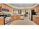 Well-lit kitchen with stainless steel appliances, tile floors, and light wood cabinetry at 506 Alleria Ct, Auburndale, FL 33823