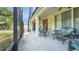 Covered patio featuring wicker seating and views of the screened-in porch at 506 Alleria Ct, Auburndale, FL 33823