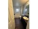 Well-lit bathroom features dark wood floors, shower-tub combo, and updated fixtures at 5719 Sweetheart Ct, St Cloud, FL 34772