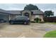Well-maintained home featuring a stone arch entrance and lush landscaping, complemented by a spacious driveway at 5719 Sweetheart Ct, St Cloud, FL 34772
