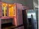 Kitchen featuring pink cabinets with under cabinet lights and stainless steel refrigerator at 5719 Sweetheart Ct, St Cloud, FL 34772