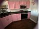 Updated kitchen with stainless steel appliances and pink cabinets at 5719 Sweetheart Ct, St Cloud, FL 34772