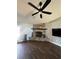 Cozy living room featuring a stone fireplace, modern ceiling fan, and dark hardwood floors at 5719 Sweetheart Ct, St Cloud, FL 34772