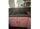 Close-up of the kitchen sink and counter, complemented by pink cabinets at 5719 Sweetheart Ct, St Cloud, FL 34772