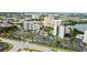 Scenic aerial view of a condominium complex featuring lush landscaping, a pool, and lake views in a vibrant urban setting at 6165 Carrier Dr # 1603, Orlando, FL 32819