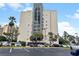 Exterior view of a towering condominium complex showcasing modern architecture and convenient parking at 6165 Carrier Dr # 1603, Orlando, FL 32819