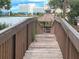 Wooden walkway leading to a gazebo on the water under a cloudy sky at 6165 Carrier Dr # 1603, Orlando, FL 32819