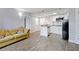 Open living space with modern kitchen and tile flooring next to a comfortable sofa at 6165 Carrier Dr # 1603, Orlando, FL 32819