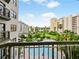 A view overlooking the community pool and lush landscaping from an outdoor balcony at 6165 Carrier Dr # 1603, Orlando, FL 32819
